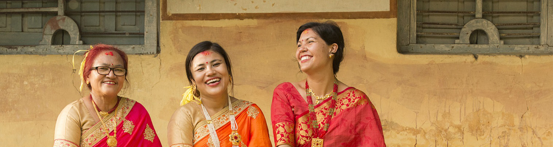 Three people in red gowns with the 'Top Producer' badge on the right