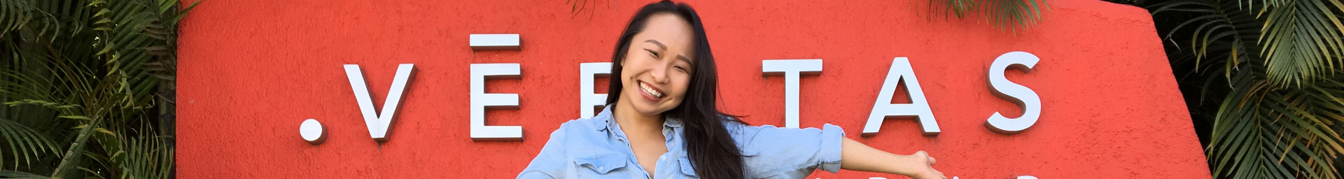 Student in front of a red sign